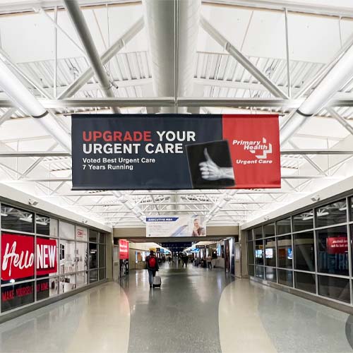 Banner hanging in hallway with image of x-ray thumbs up and text that reads "Upgrade your urgent care"