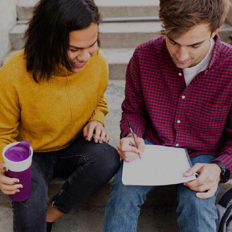 photo of two young adults working on a sketchbook