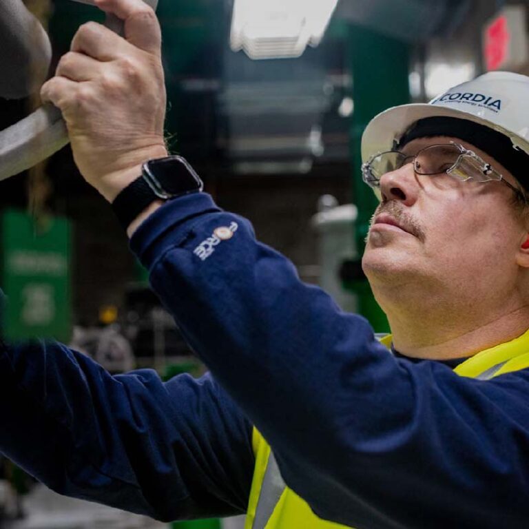 photo of a man in safety gear lifting a metal object