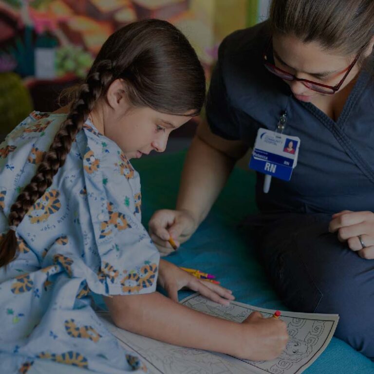 photo of an RN assisting a child create art