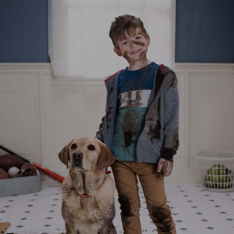 photo of a dirt-covered child and dog in a bathroom