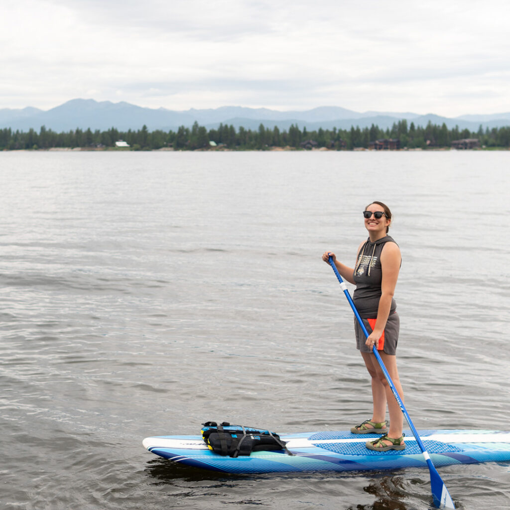 Maddie Godwin paddle-boarding on a lake