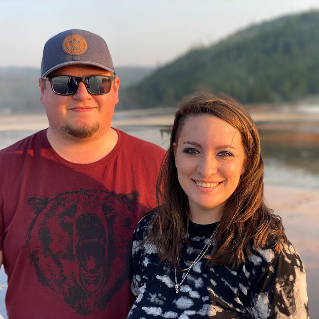 Maddie Godwin with their partner in front of a river