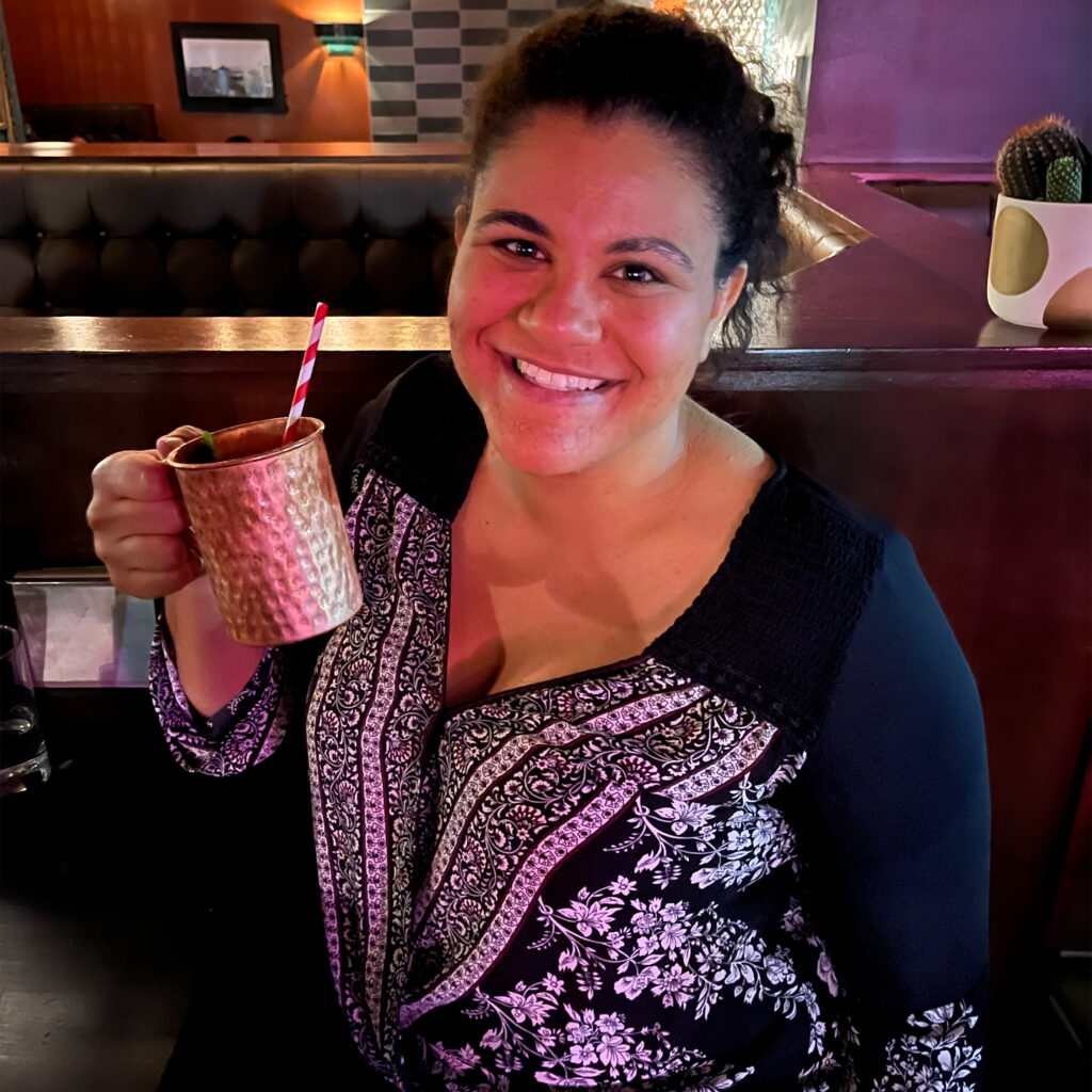 Mikayla Williams holding a copper mug with a twisty straw