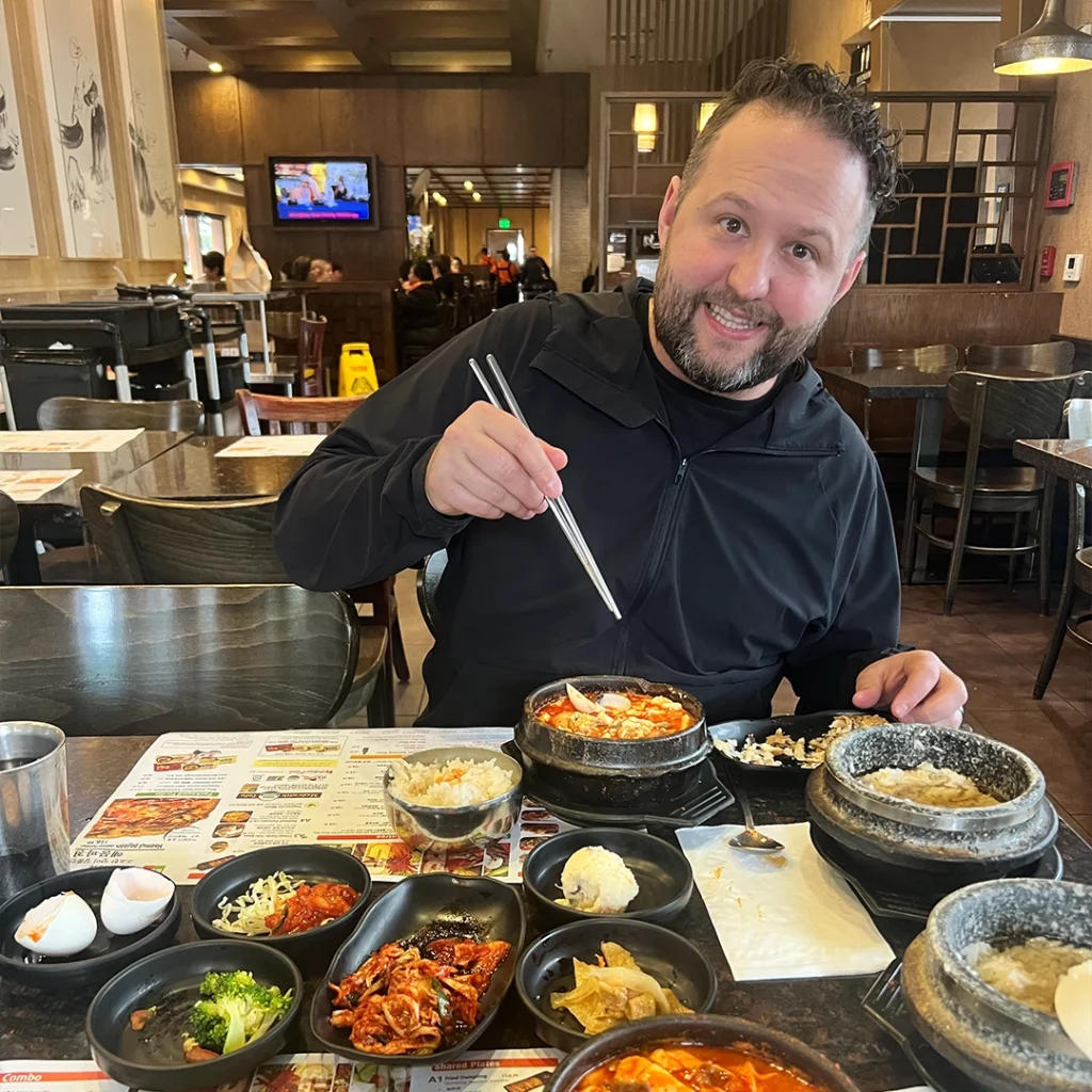 Photo of Chris Watts enjoying a meal with chop sticks in his hands